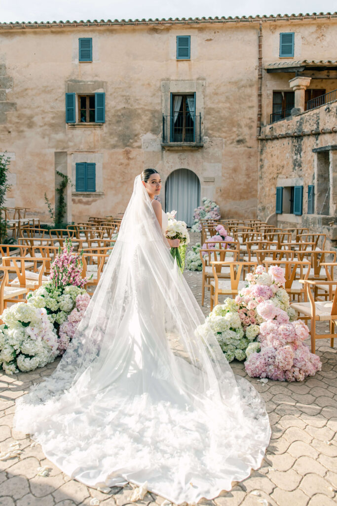 Bride in elegant gown walking down the aisle at Son Sampol during Mallorca destination wedding